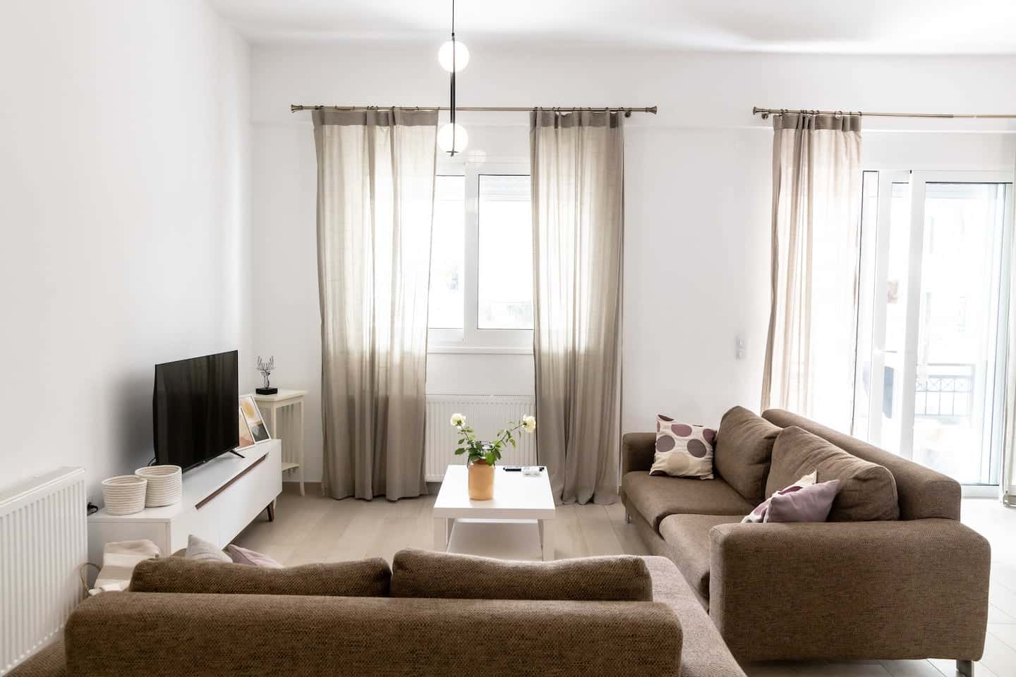 Bright, sunlit living room with large windows at Donum House in Heraklion, Crete
